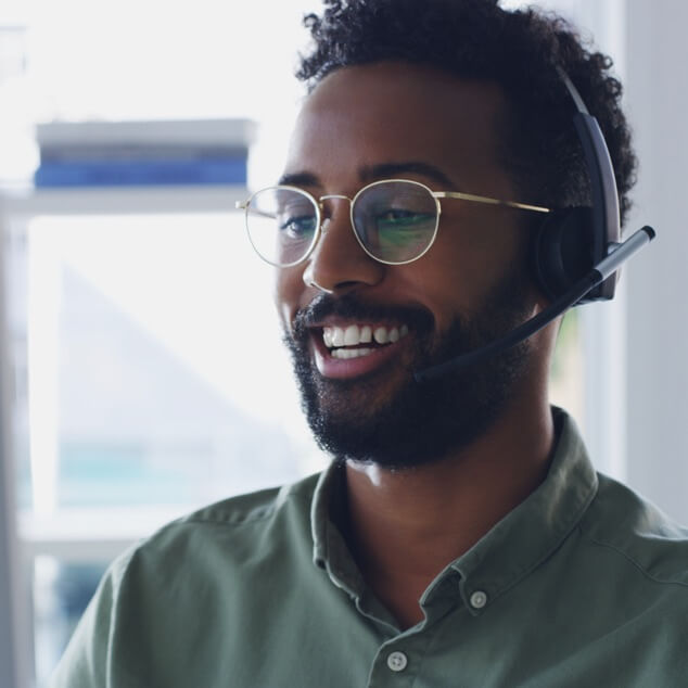 A closeup of man wearing glasses and smiling as he speaks. 