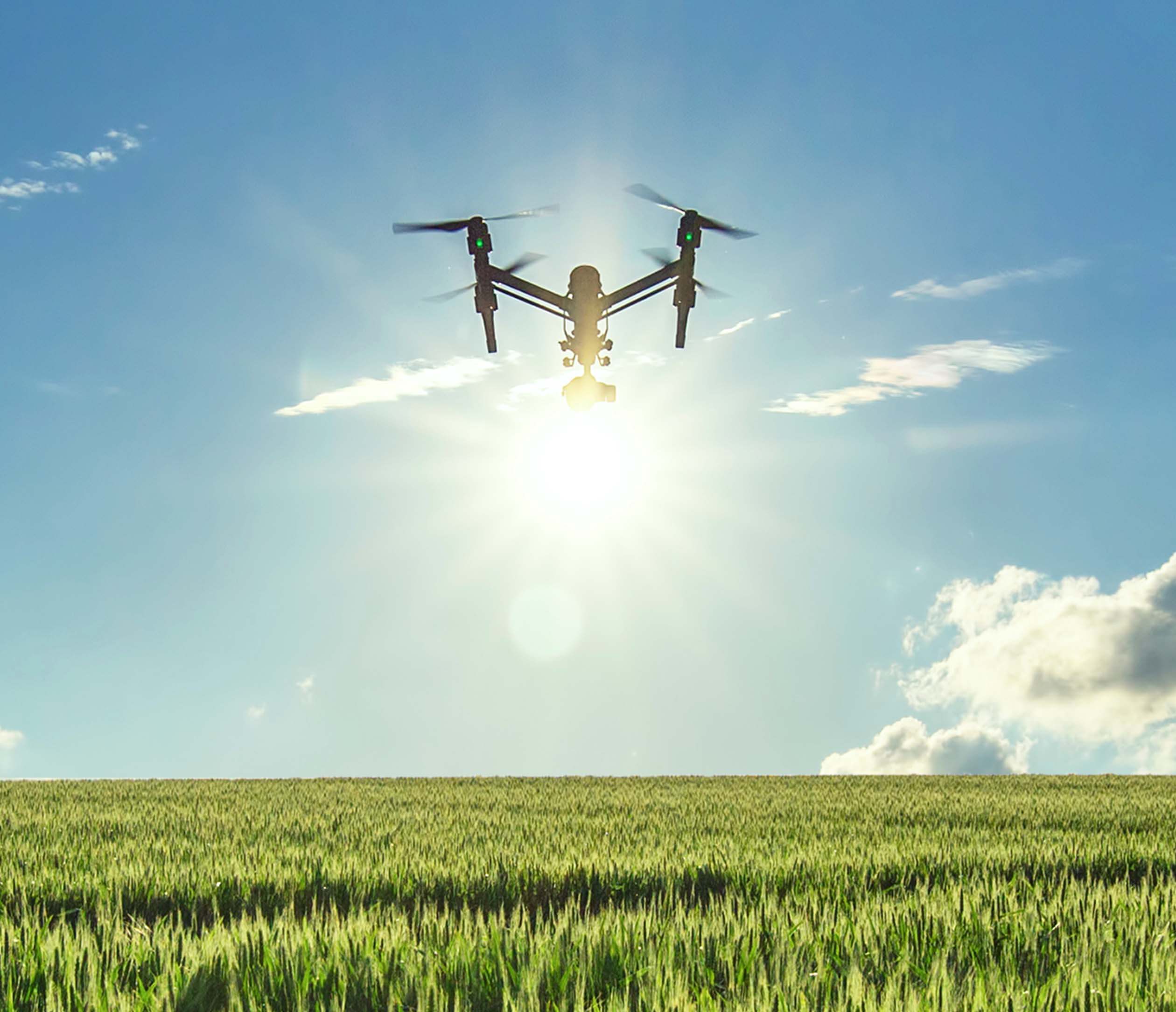 Agricultrual drone above a field with sunny sky