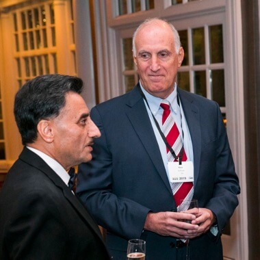 Two businesspeople talking and smiling at ANSI Awards reception. 